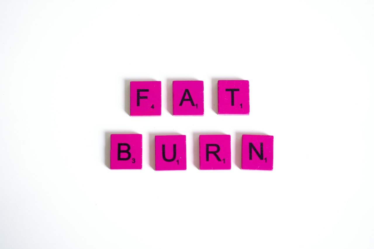 arranged puzzle pieces of letters that form the words "fat burn"