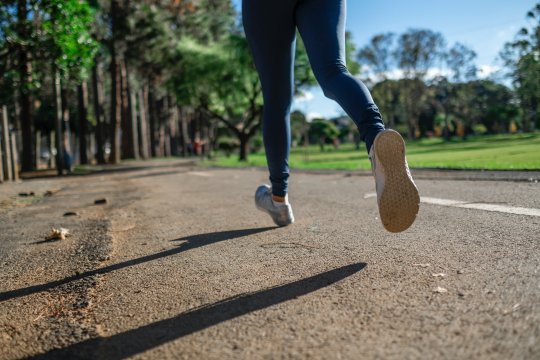 A person running down a road with trees in the background